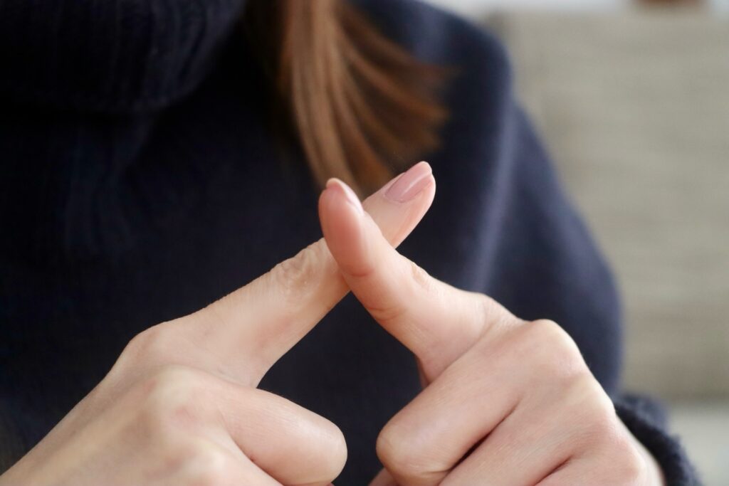 バツポーズの女性の手