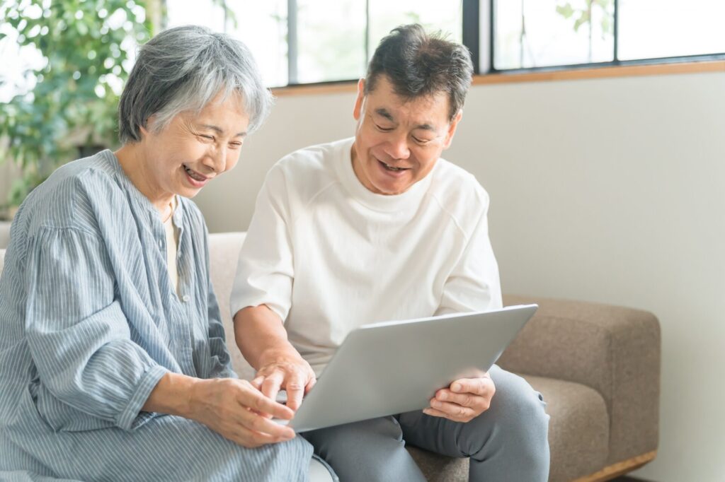 ノートパソコンを使う高齢者夫婦