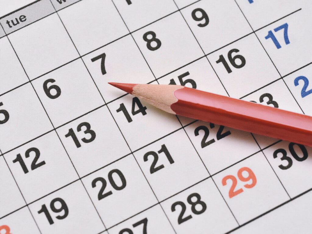 赤鉛筆とカレンダーの日付