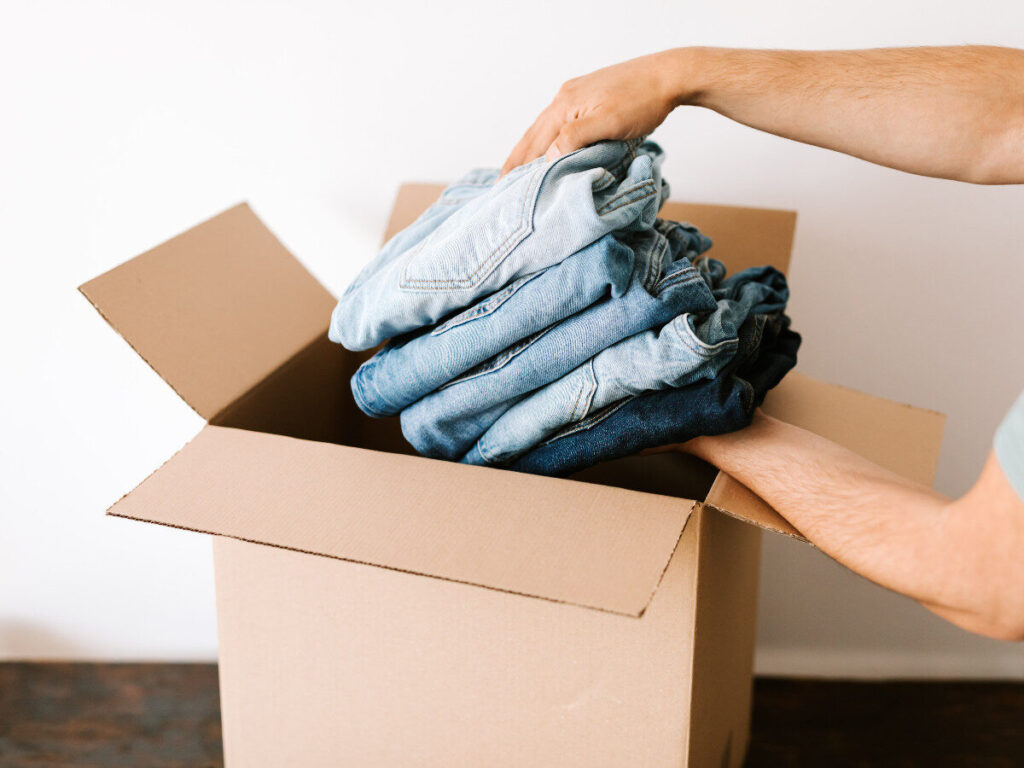 ダンボールにジーンズを詰める手元