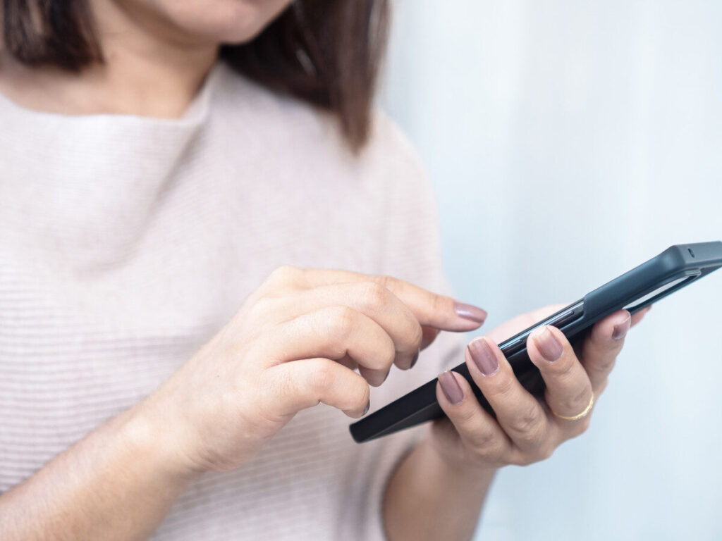 スマートフォンを操作する女性の手元のアップ