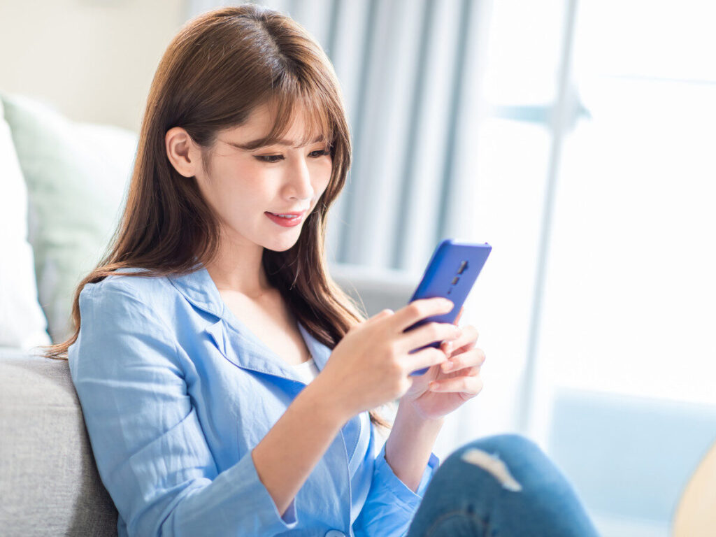 スマホで買取査定を依頼する女性