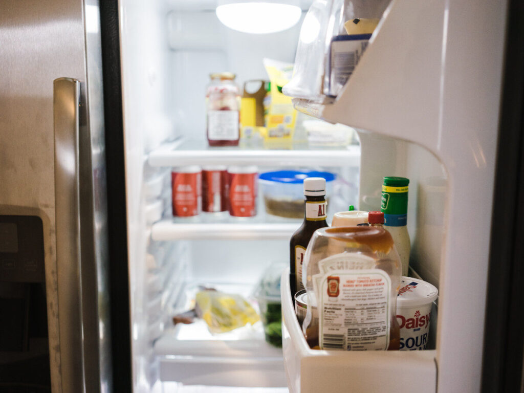 家庭用冷蔵庫の中に調味料や瓶詰めが雑然と収納されている様子