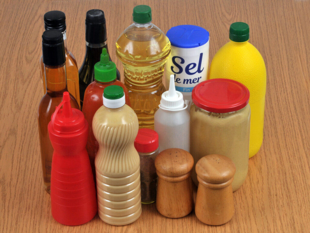 さまざまな調味料のボトルや瓶がテーブルの上に並べられている